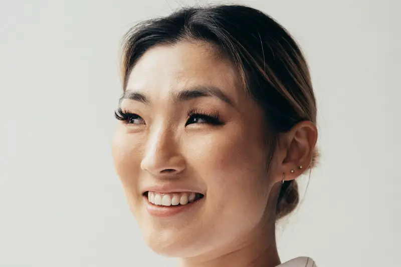 smiling asian woman wearing false eyelashes