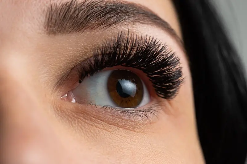close-up of a beautiful woman's eye wearing eyelash extensions attached with eyelash extension glue